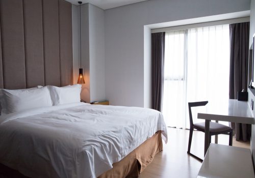 hotel-bedroom-with-double-bed-table-tv-set_1262-3034